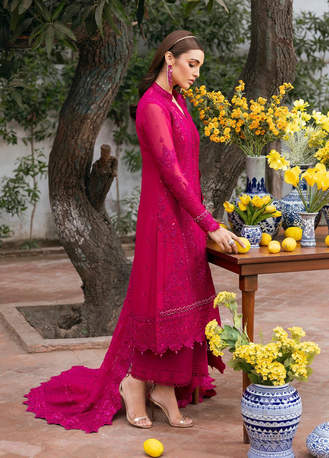 Model wearing Gulaal Zevira hot pink embroidered chiffon dress with matching dupatta and trousers. Shop Pakistani clothes online in the UK now.