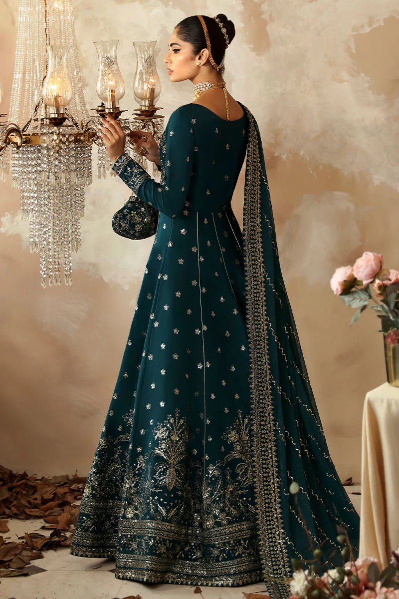 Model in a luxurious deep teal Gulaal Shehrnaaz Raw Silk kalidaar outfit featuring intricate embroidery and sequins, with an embroidered chiffon dupatta and organza borders, perfect for festive occasions.