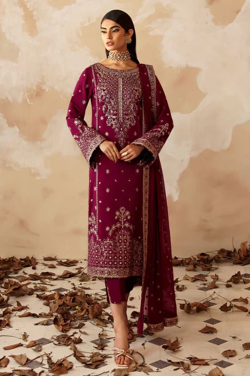 Model wearing a stunning deep maroon Shehrnaaz Raw Silk outfit by Gulaal. This festive ensemble features intricate embroidery and sequins on silk, paired with an embroidered chiffon dupatta and silk trousers, perfect for elegant occasions.