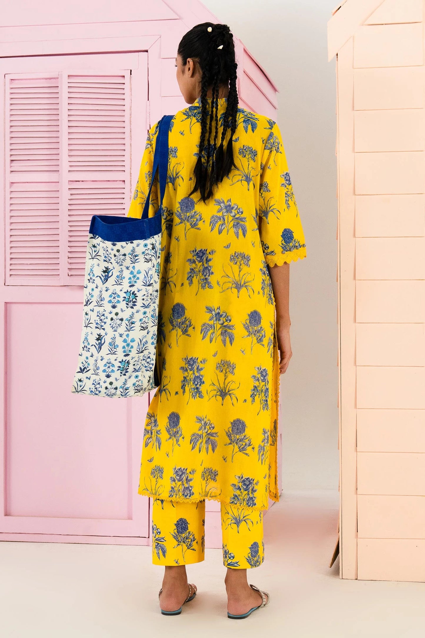 Model wearing Sana Safinaz Mahay'24 yellow lawn dress with floral print, Pakistani summer attire, available in UK.