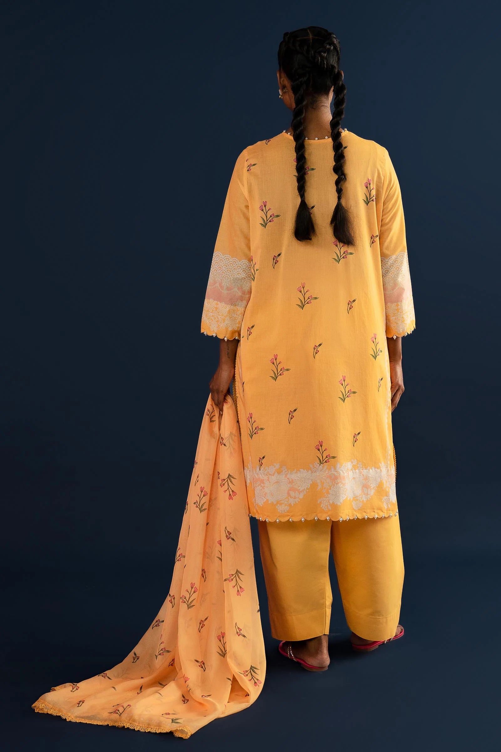 Model wearing yellow embroidered Pakistani lawn clothing for summer.