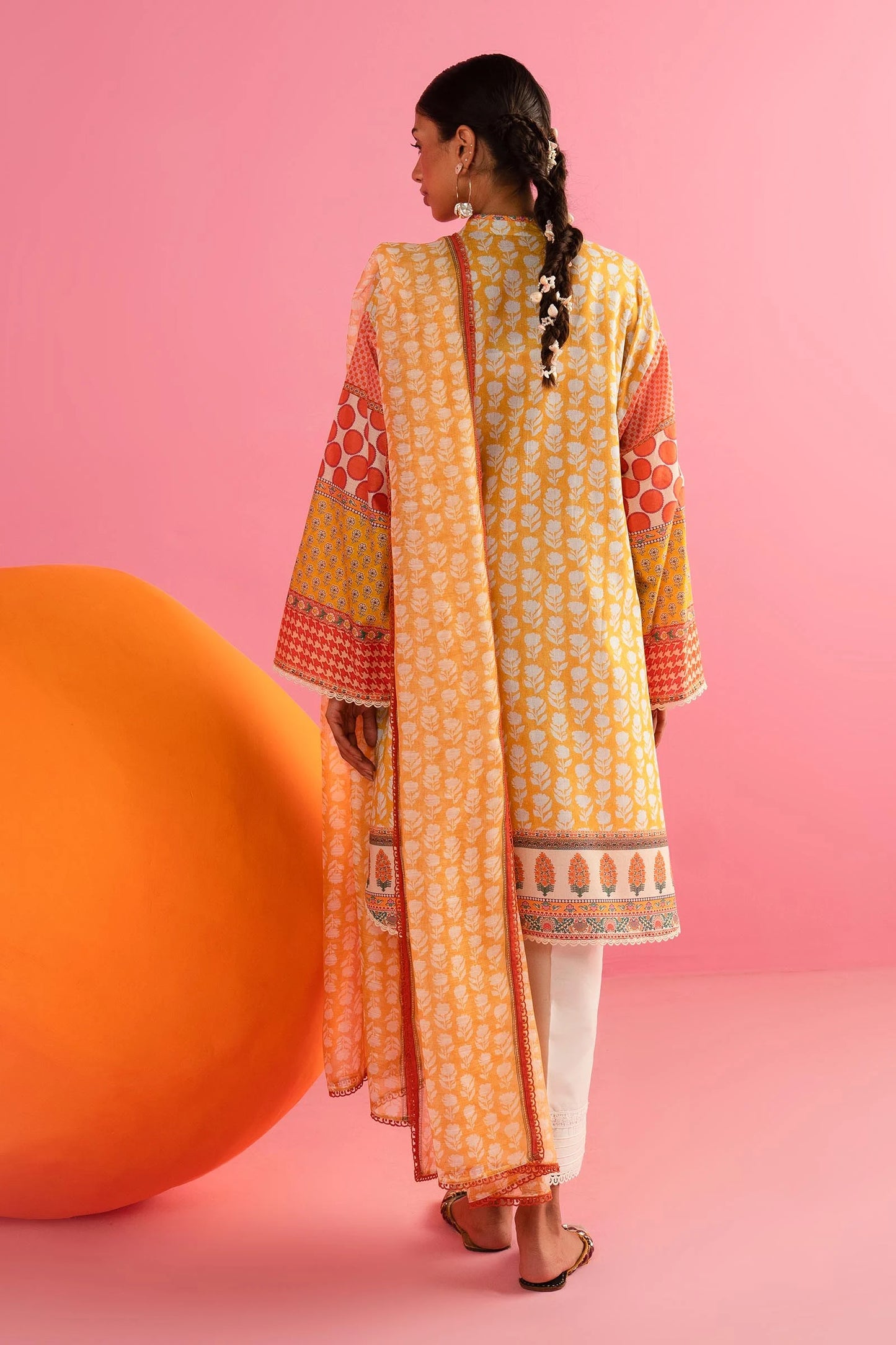 Model in Sana Safinaz 242 - 019A - 2DD yellow and red printed Pakistani lawn suit with white pants.