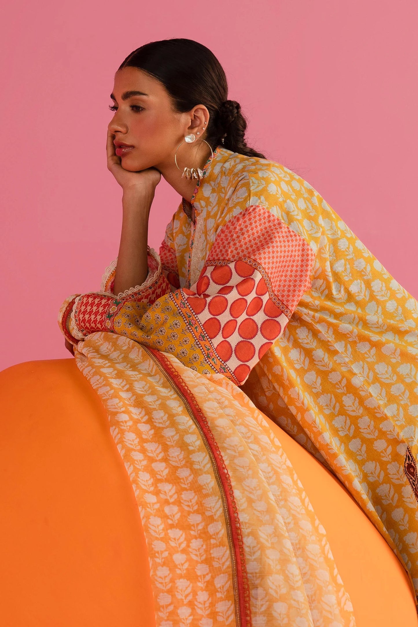 Model in Sana Safinaz 242 - 019A - 2DD yellow and red printed Pakistani lawn suit with white pants.