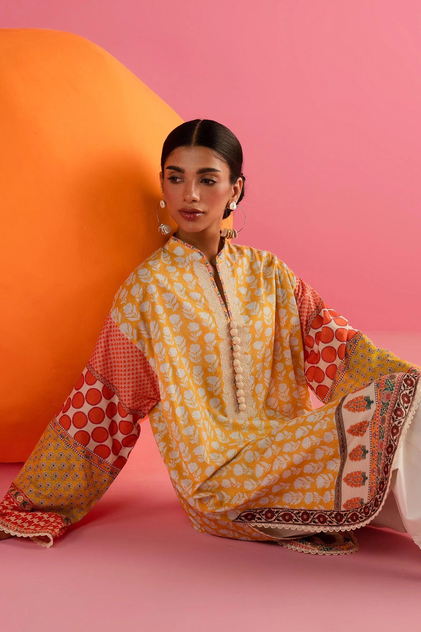 Model in Sana Safinaz 242 - 019A - 2DD yellow and red printed Pakistani lawn suit with white pants.