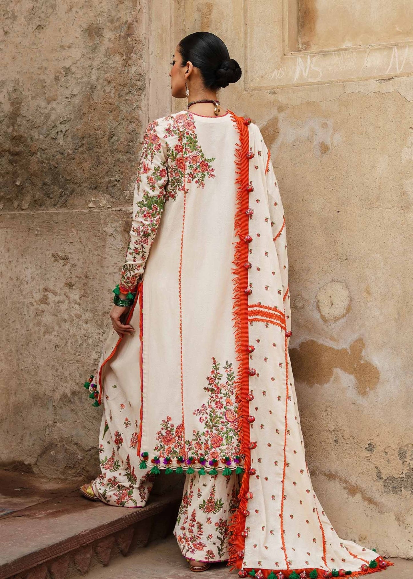 Model wearing Hussain Rehar Karandi Aw'23 Bellis dress in cream with floral patterns, showcasing Pakistani clothes online in the UK.