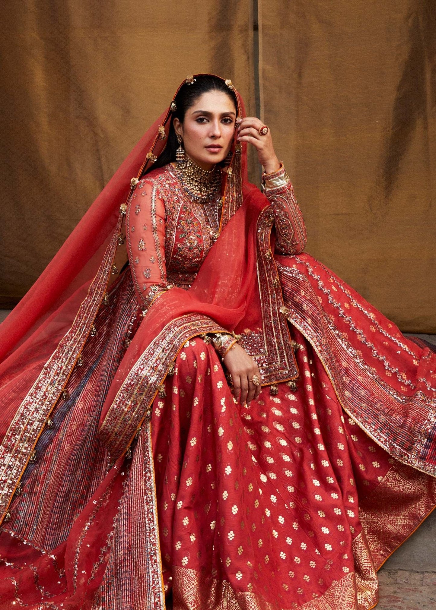 Model wearing red Bulori dress from Hussain Rehar Luxury Festive FW/24, featuring intricate embroidery and embellishments. Pakistani clothes online in the UK.