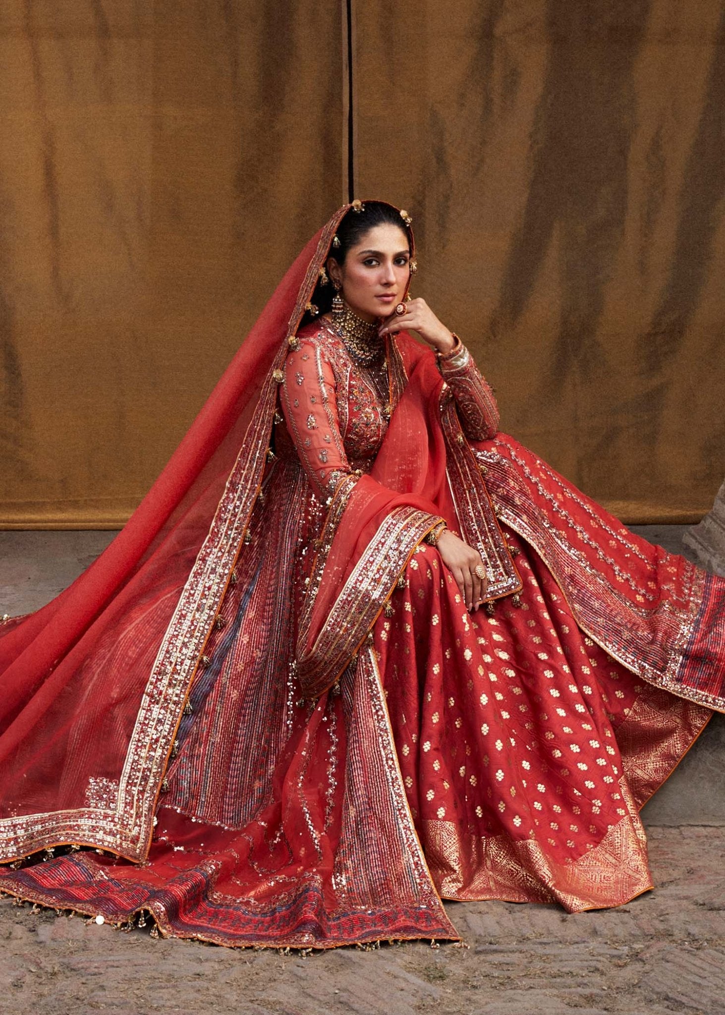 Model wearing red Bulori dress from Hussain Rehar Luxury Festive FW/24, featuring intricate embroidery and embellishments. Pakistani clothes online in the UK.