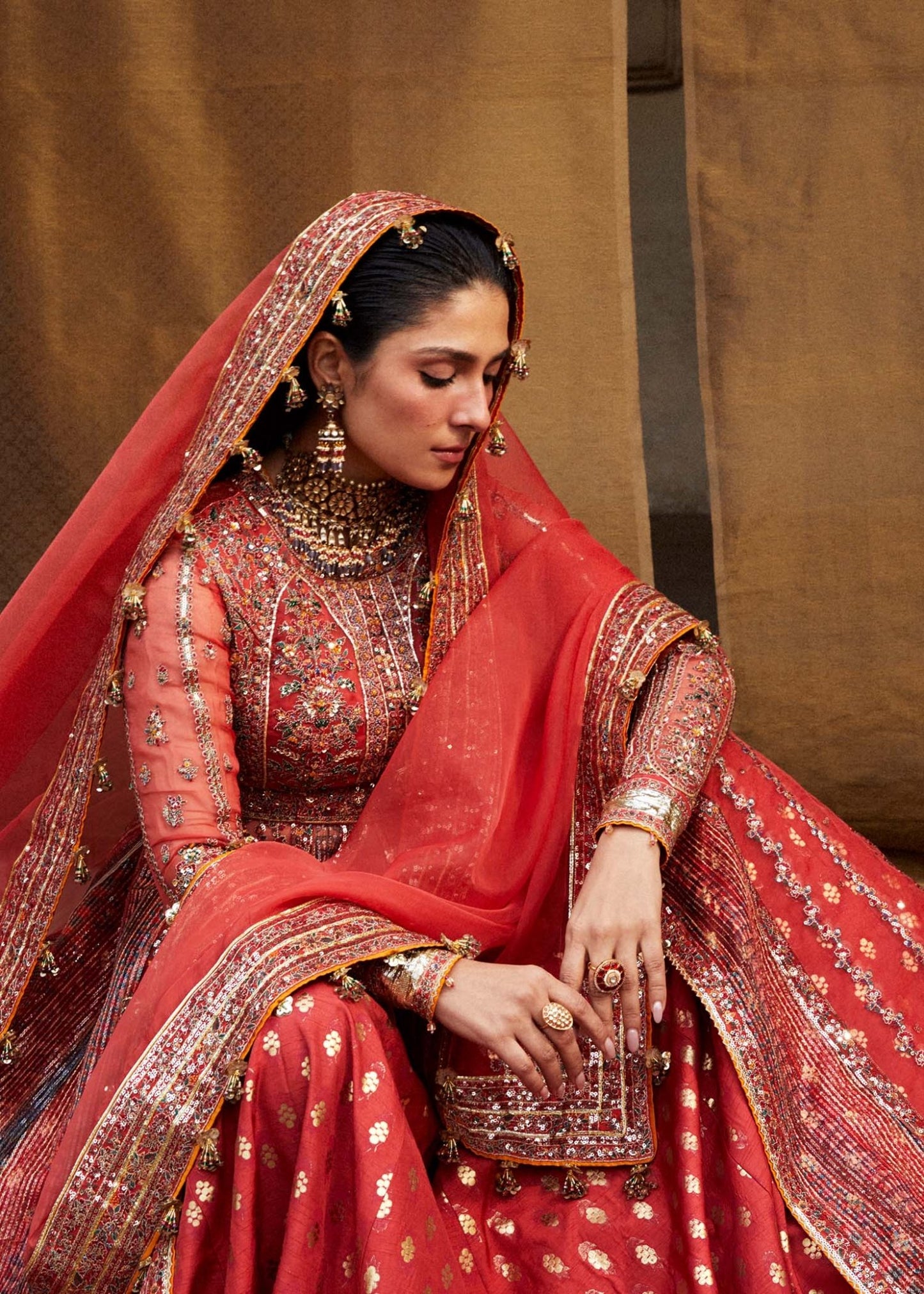 Model wearing red Bulori dress from Hussain Rehar Luxury Festive FW/24, featuring intricate embroidery and embellishments. Pakistani clothes online in the UK.