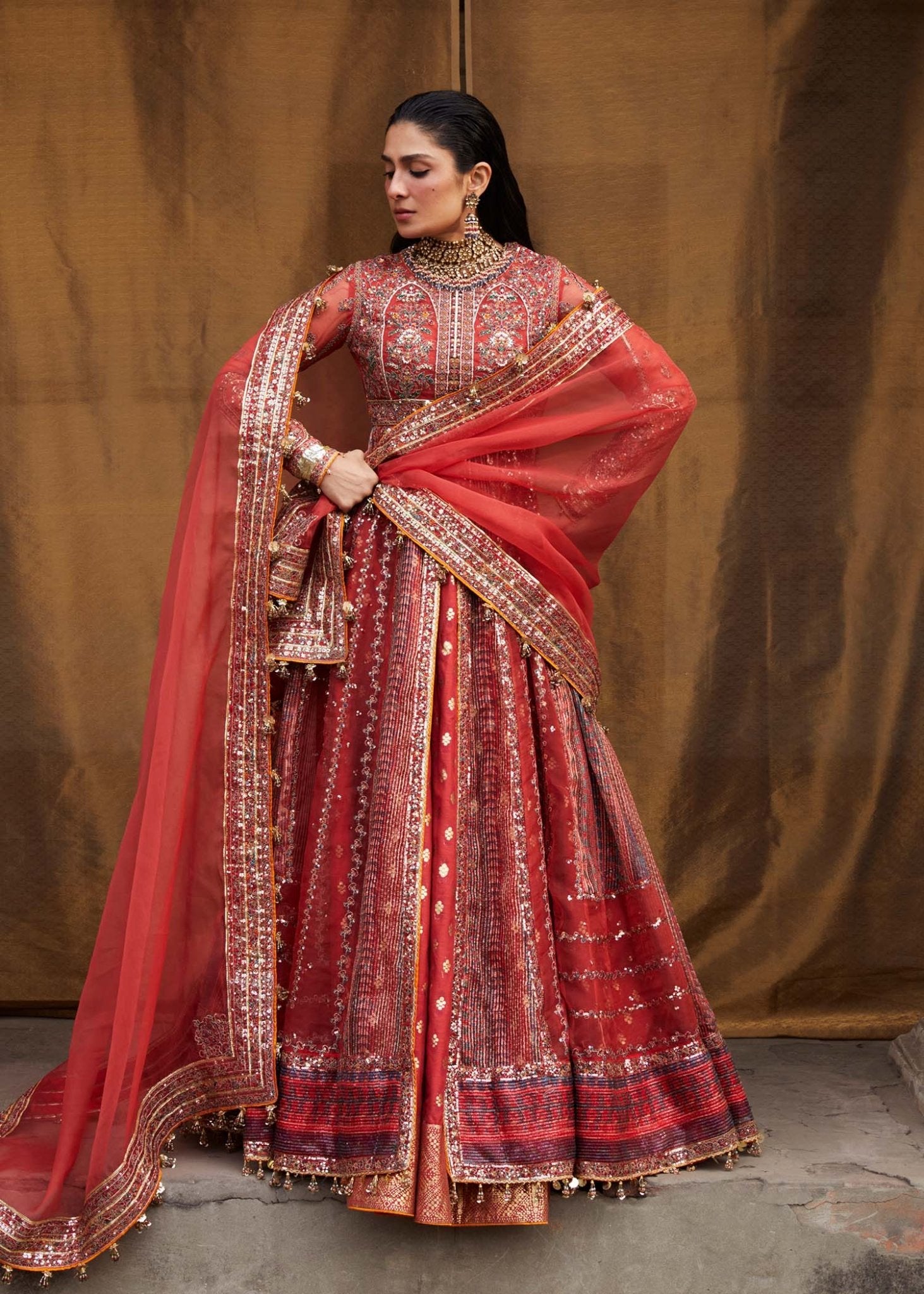 Model wearing red Bulori dress from Hussain Rehar Luxury Festive FW/24, featuring intricate embroidery and embellishments. Pakistani clothes online in the UK.