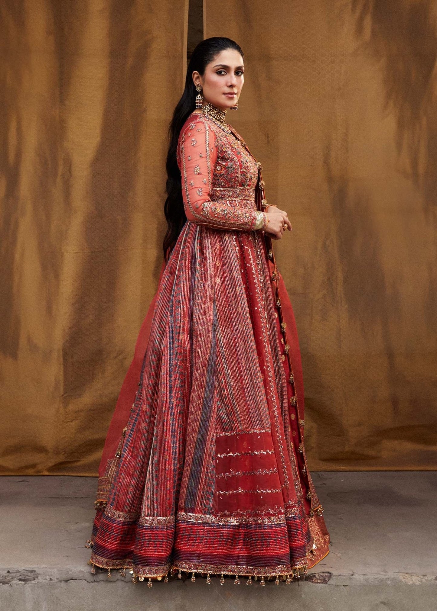 Model wearing red Bulori dress from Hussain Rehar Luxury Festive FW/24, featuring intricate embroidery and embellishments. Pakistani clothes online in the UK.