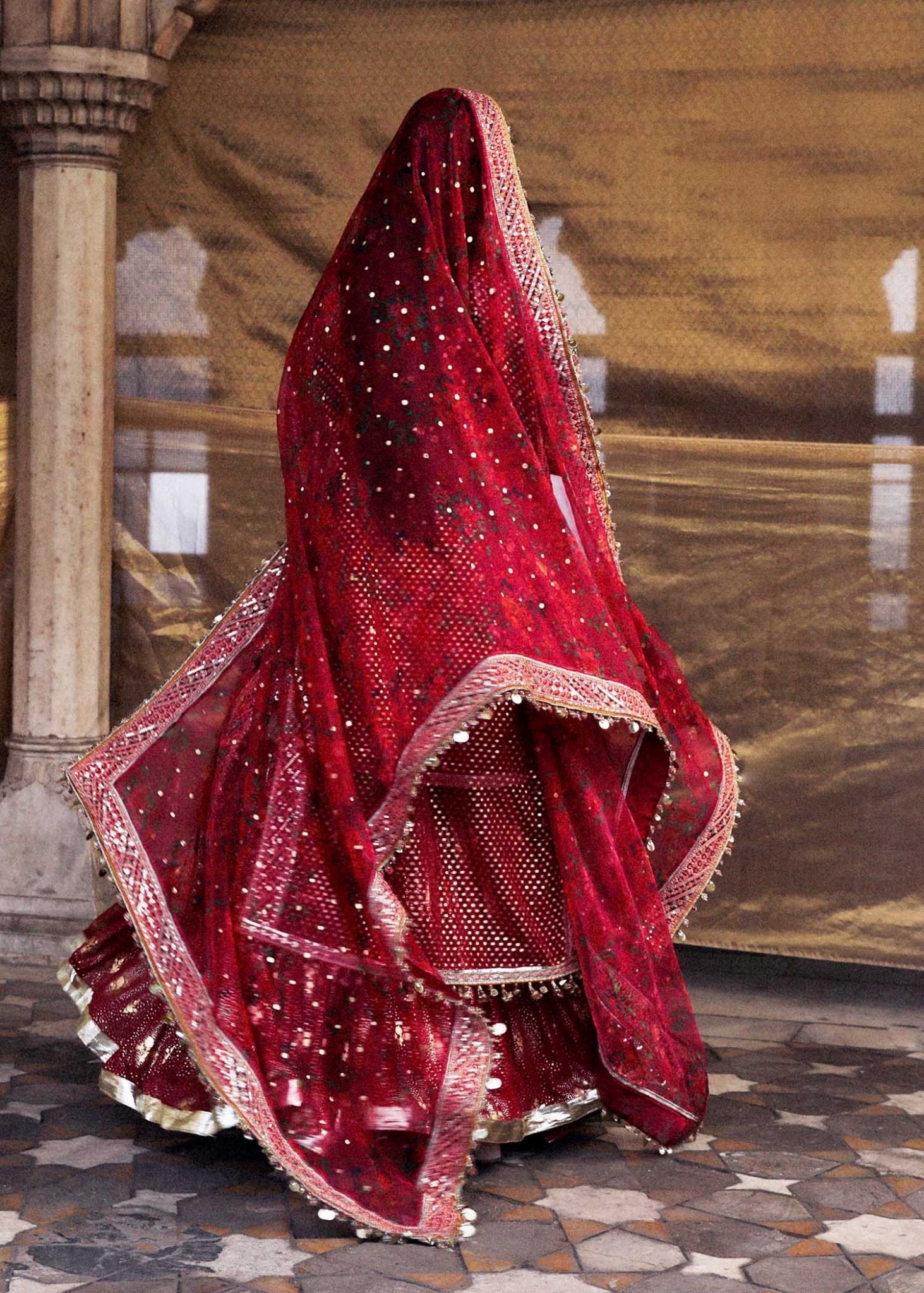 Model wearing red Gulal dress from Hussain Rehar Luxury Festive FW/24, featuring intricate embroidery. Pakistani clothes online UK.