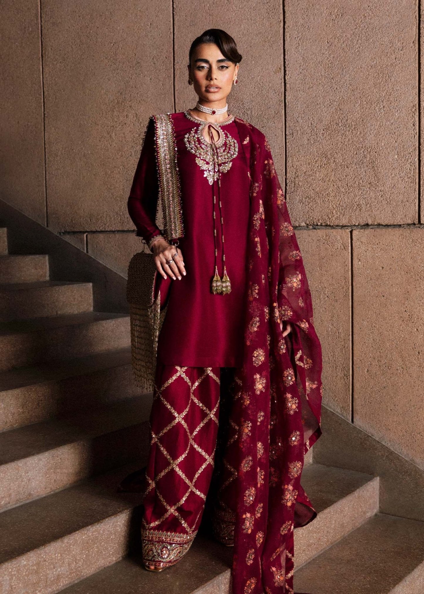 Model wearing an exquisite maroon Merlot dress from Hussain Rehar's Luxury Pret Eid '24 collection. Pakistani clothes online in UK.