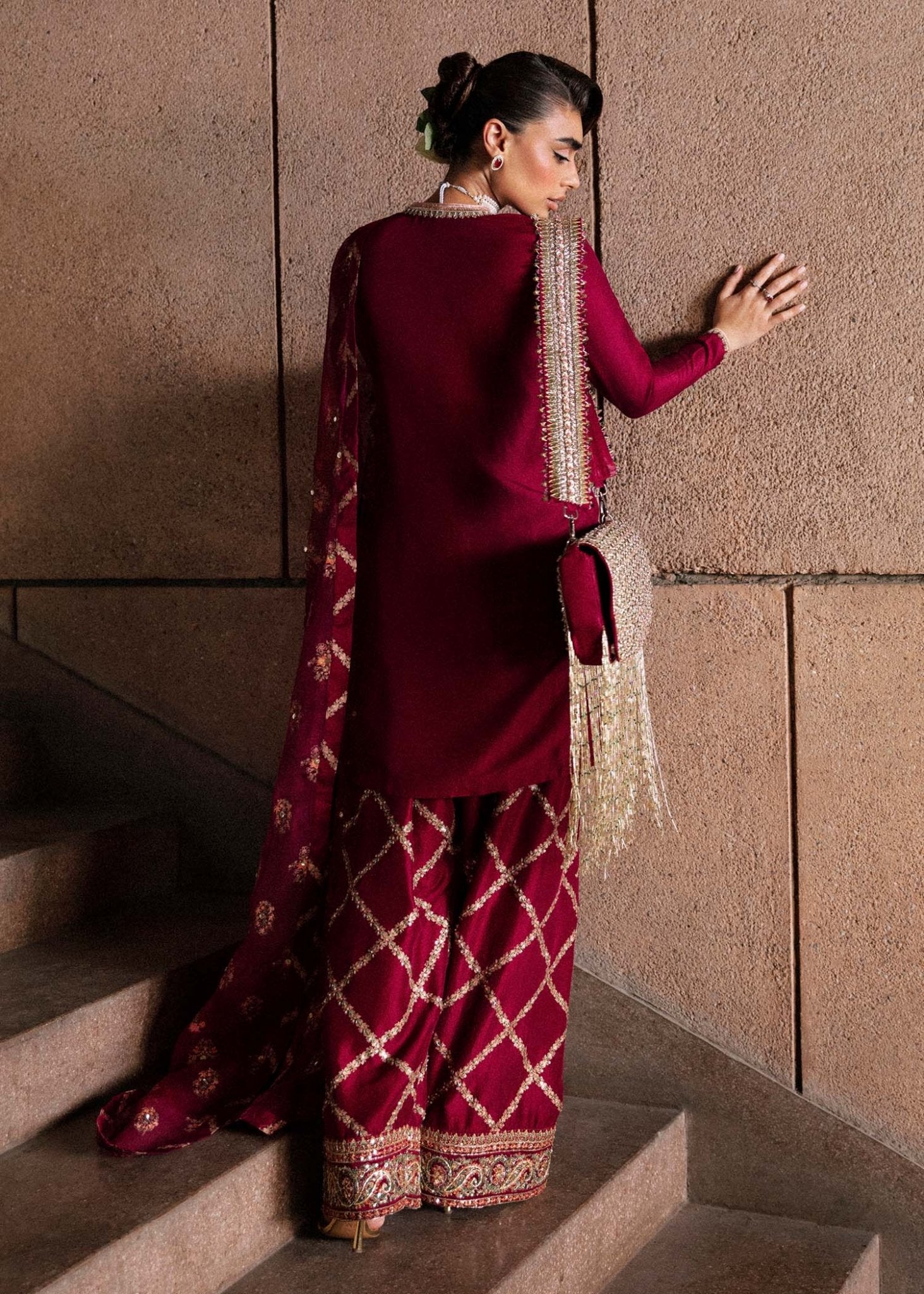 Model wearing an exquisite maroon Merlot dress from Hussain Rehar's Luxury Pret Eid '24 collection. Pakistani clothes online in UK.