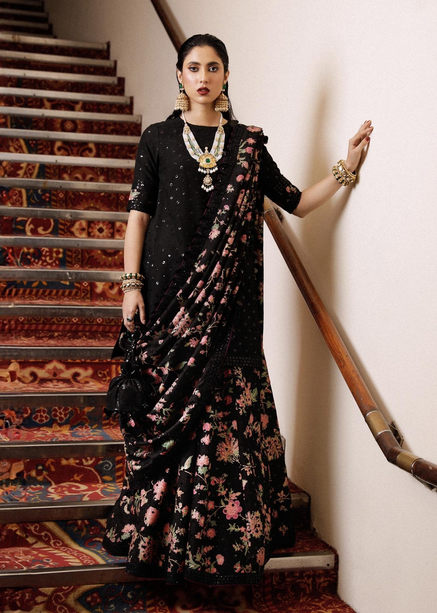 Model wearing Hussain Rehar Khaq dress in black with pink floral embroidery, perfect for Eid and luxury Pakistani lawn suits in the UK.