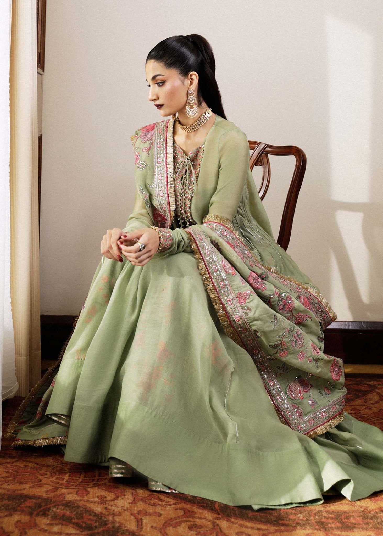 Model wearing a green Pahari dress from Hussain Rehar's Luxury Pret SS/24 collection. Pakistani clothes online in UK.