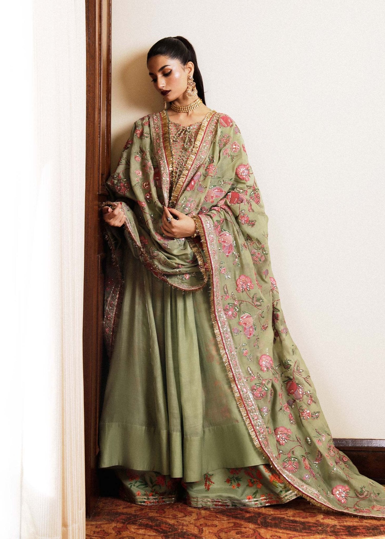 Model wearing a green Pahari dress from Hussain Rehar's Luxury Pret SS/24 collection. Pakistani clothes online in UK.