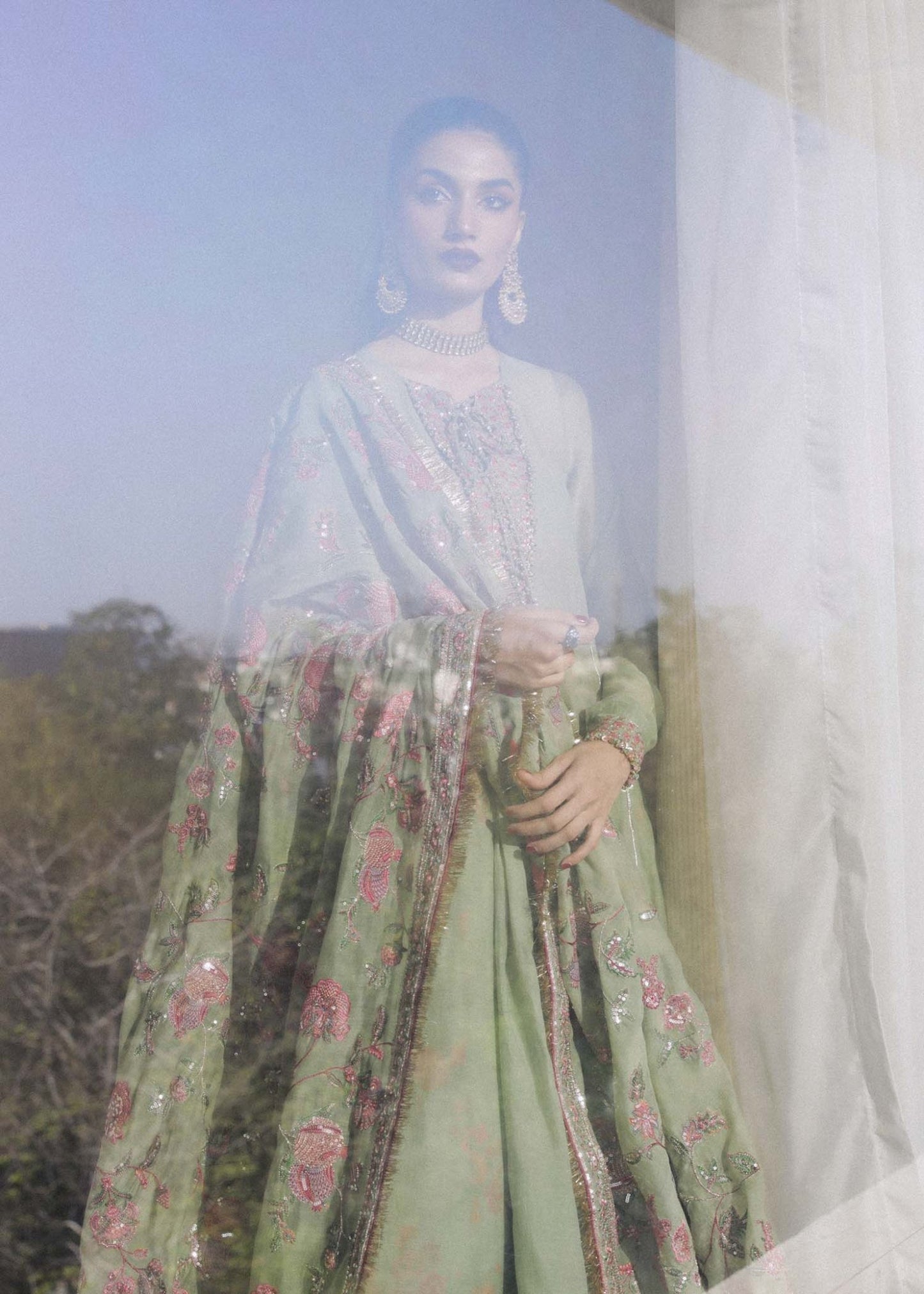 Model wearing a green Pahari dress from Hussain Rehar's Luxury Pret SS/24 collection. Pakistani clothes online in UK.