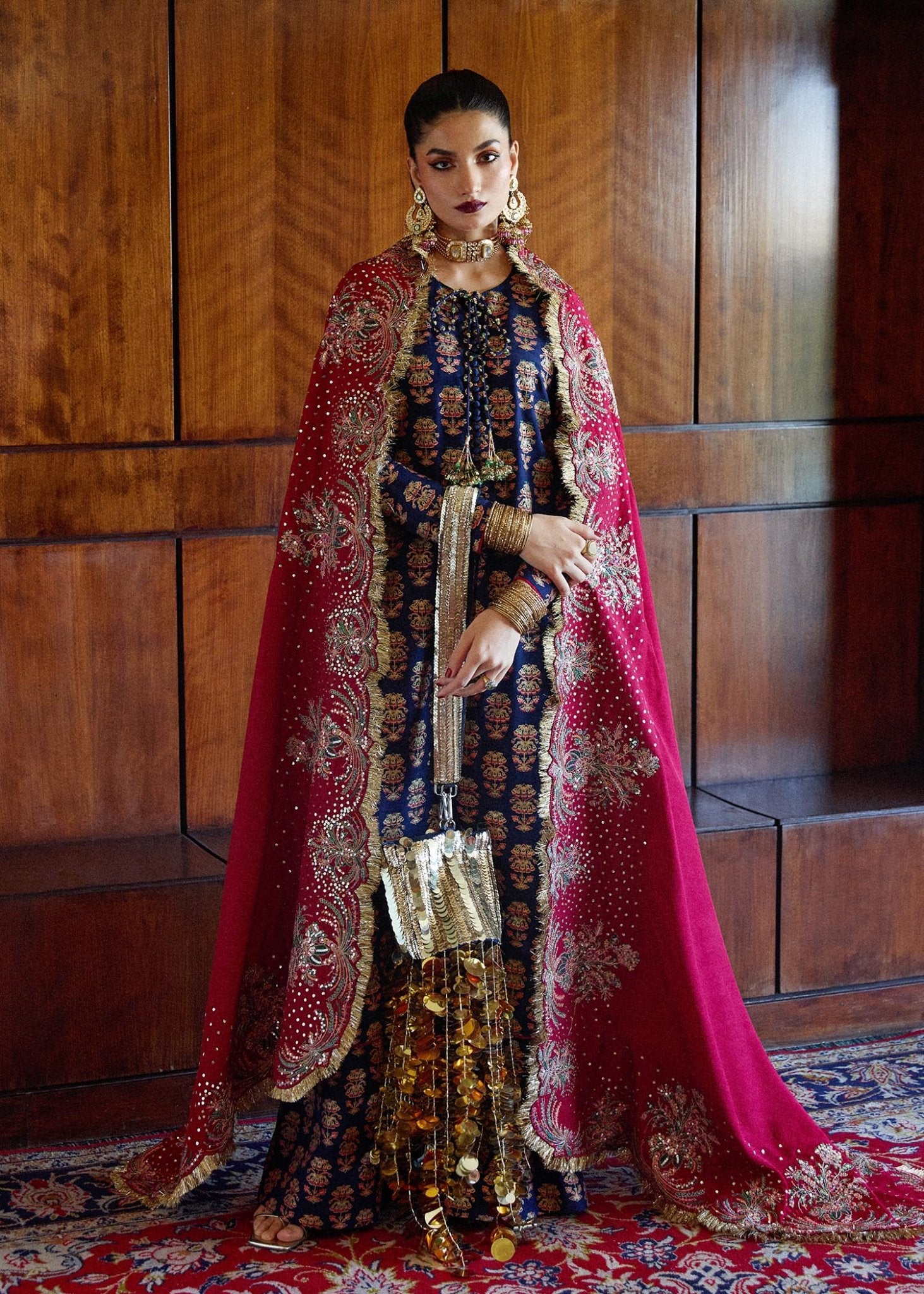 Model wearing Hussain Rehar Pur dress in navy blue with red dupatta, richly embroidered for Eid and luxury Pakistani lawn suits in the UK.