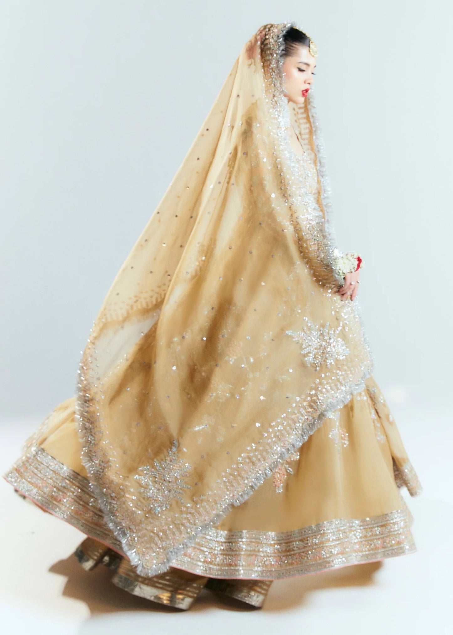 Model wearing a golden Hussain Rehar Aether dress from the Sitaray Formals collection, embellished with intricate silver embroidery.