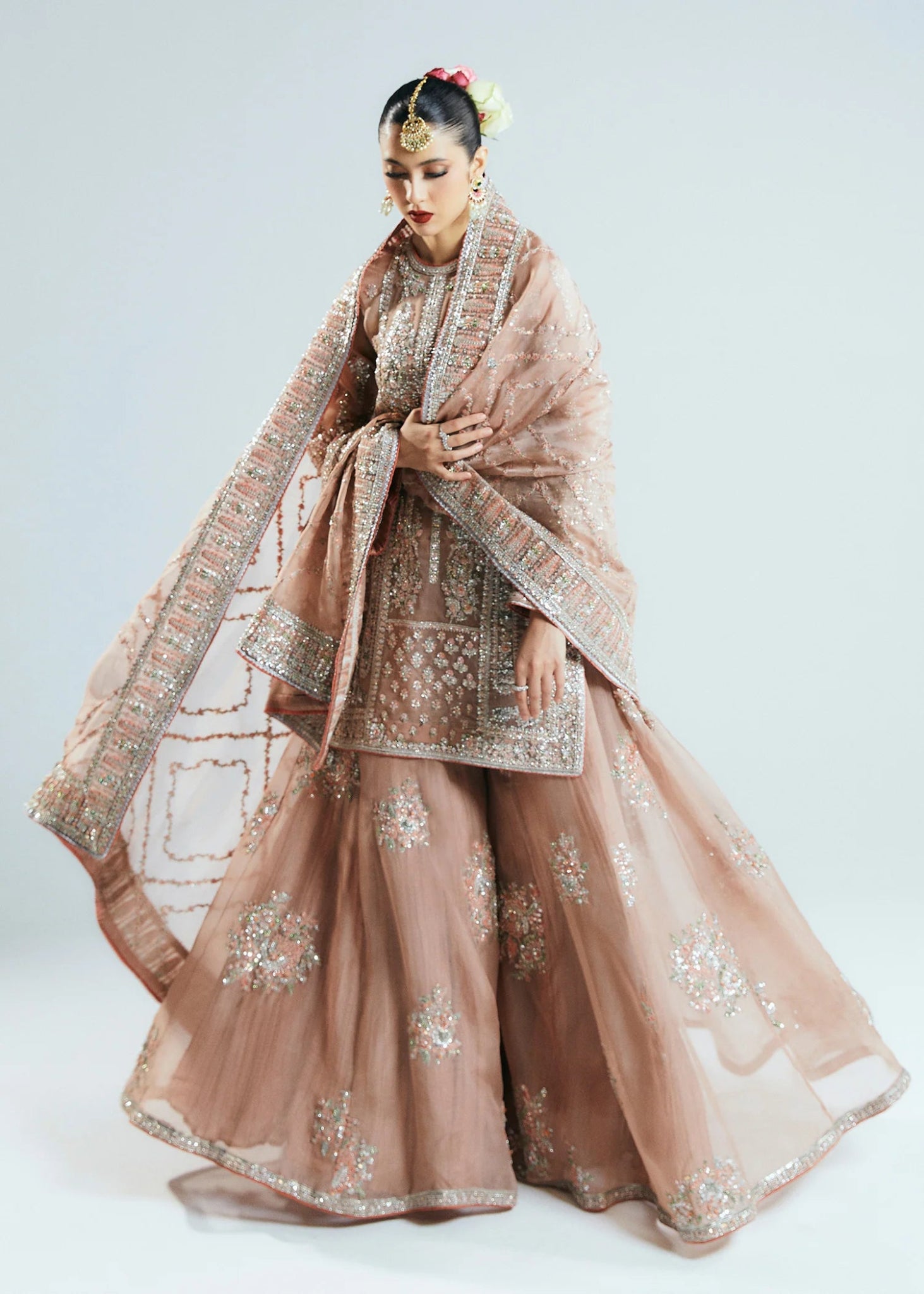 Model wearing a beige Dune dress from Hussain Rehar's Sitaray Formals collection. The dress features intricate embroidery and embellishments, perfect for wedding attire. Available for Pakistani clothes online in the UK.