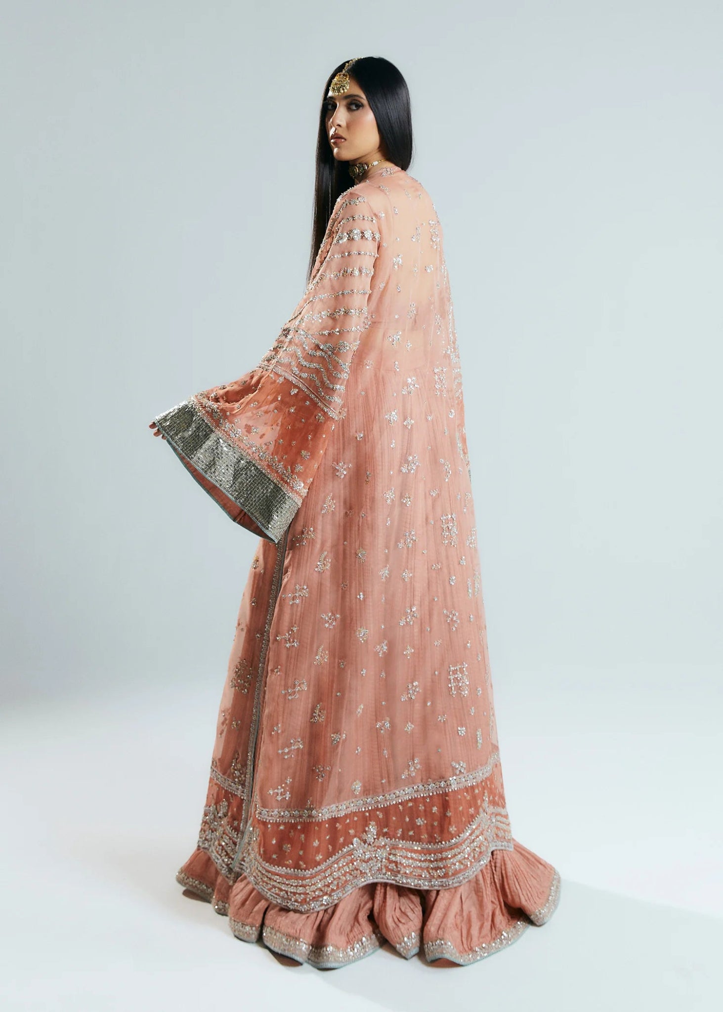 Model wearing a pink embellished Dusk dress from Hussain Rehar's Sitaray Formals collection. Perfect for Pakistani wedding clothes online in UK.