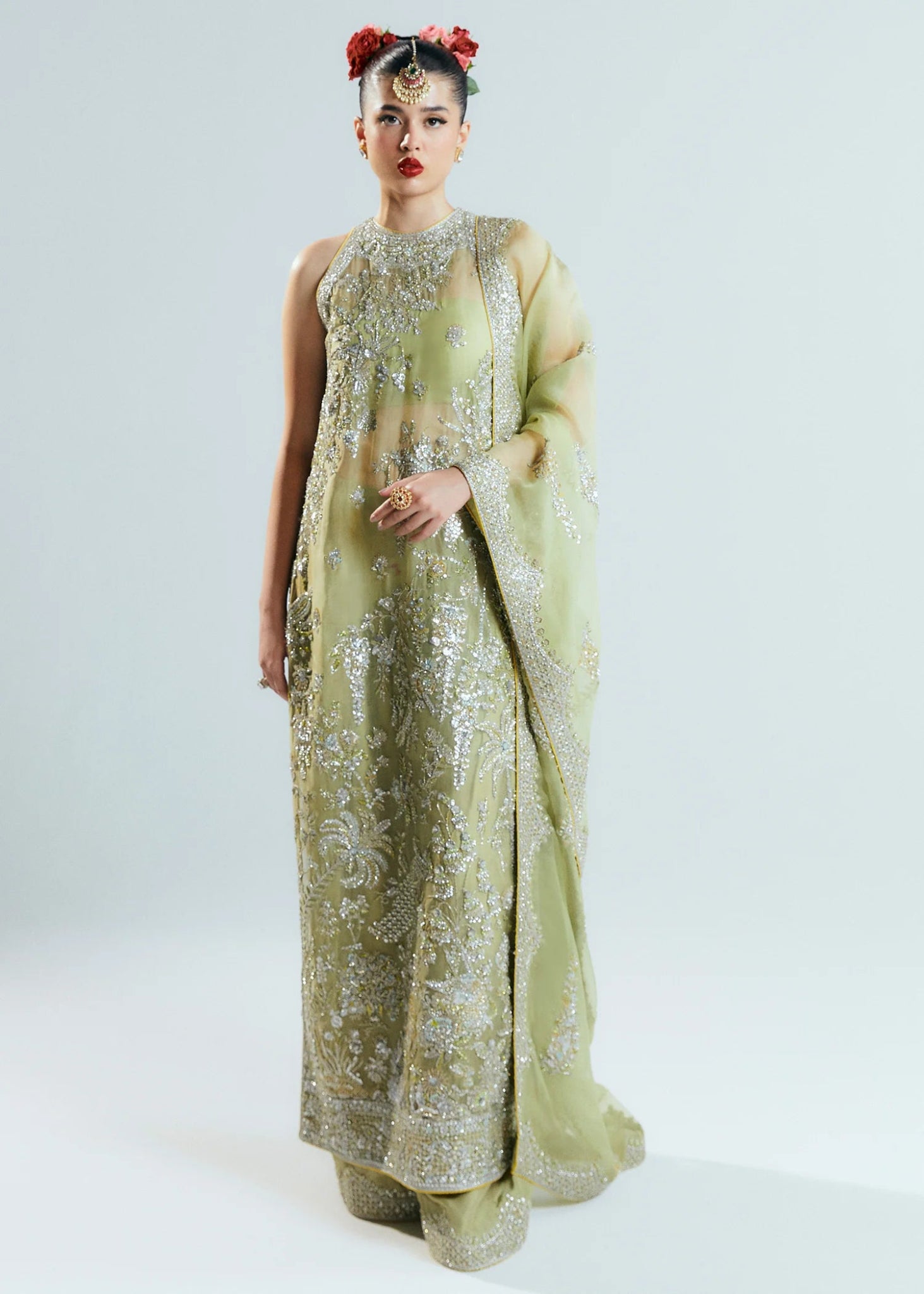 Model wearing a pastel green Mintara dress by Hussain Rehar, featuring intricate silver embroidery, perfect for weddings. Pakistani clothes online UK.