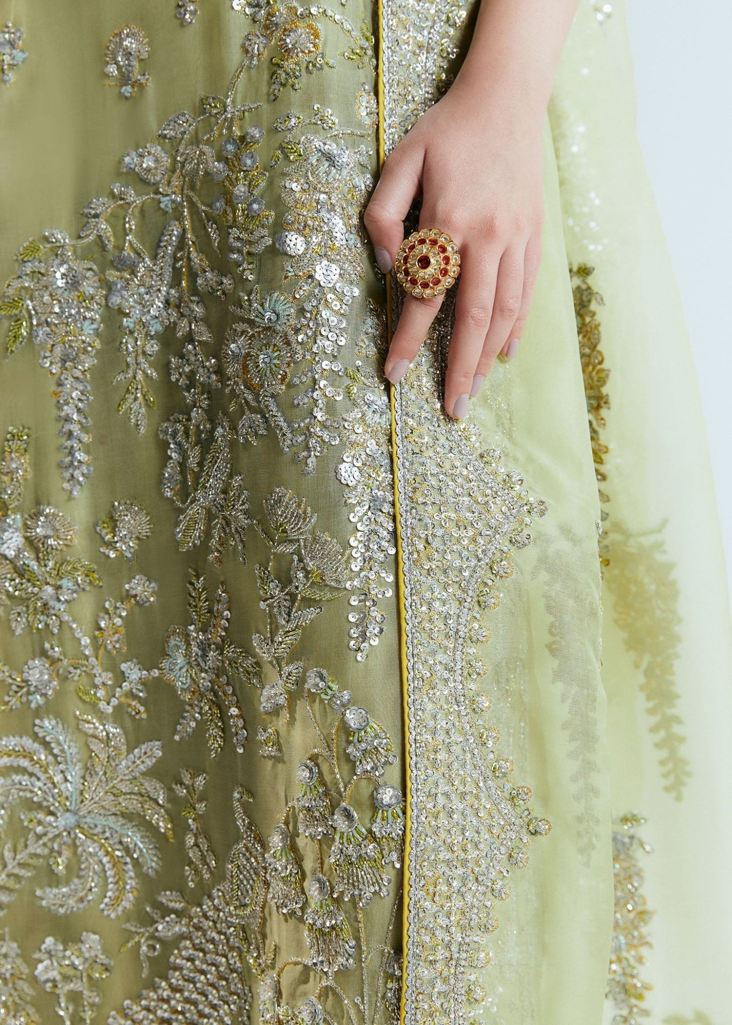 Model wearing a pastel green Mintara dress by Hussain Rehar, featuring intricate silver embroidery, perfect for weddings. Pakistani clothes online UK.