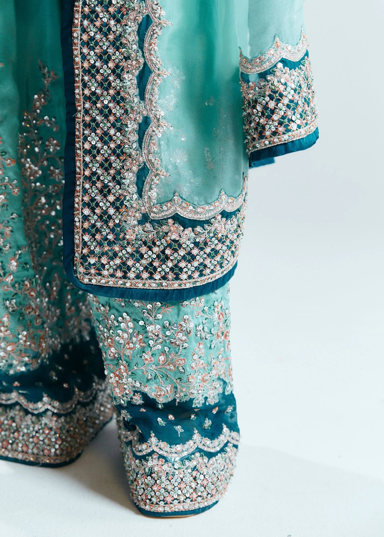 Model wearing a teal Hussain Rehar Reef dress with intricate embellishments from the Sitaray Formals collection. Perfect for weddings.