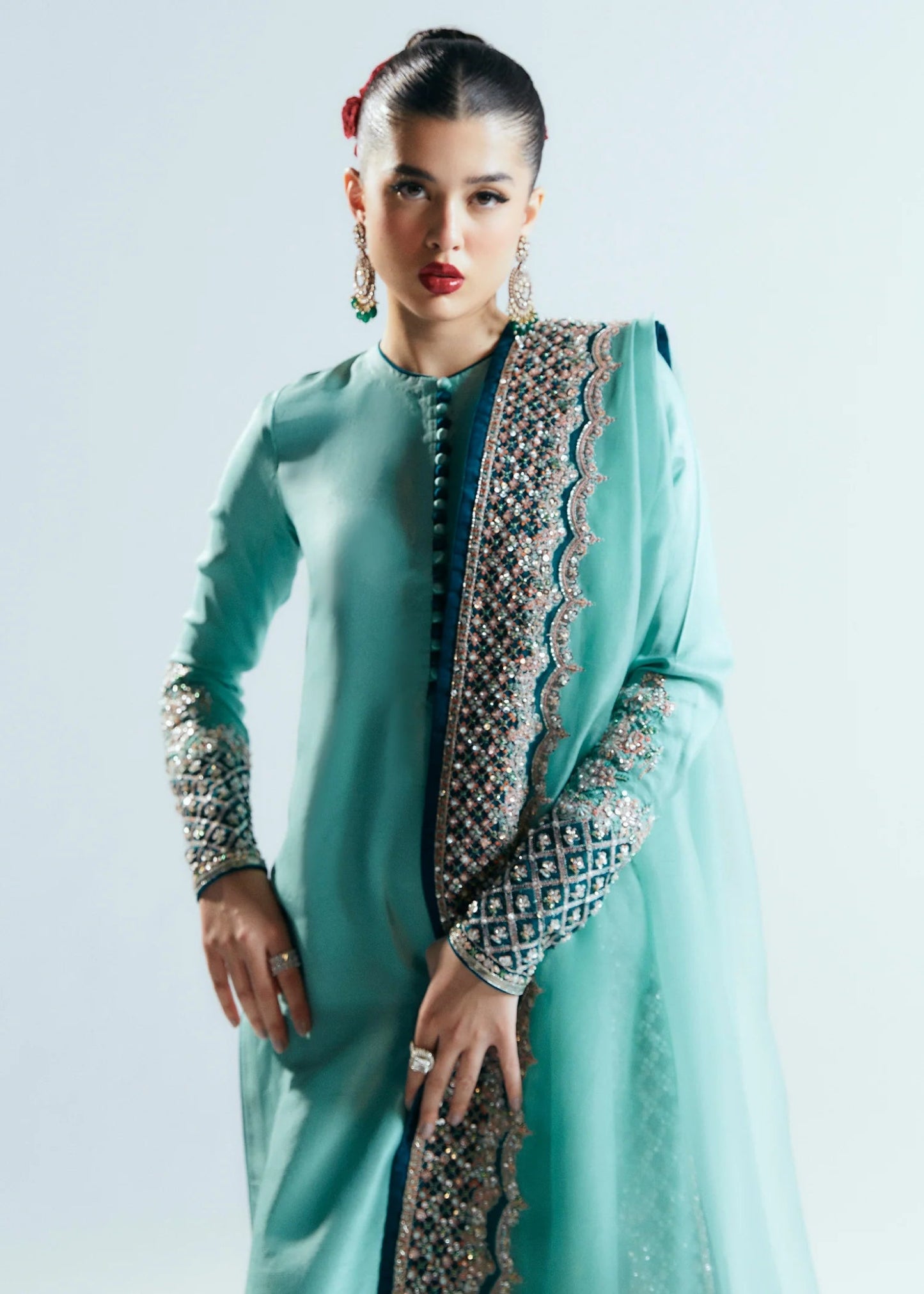 Model wearing a teal Hussain Rehar Reef dress with intricate embellishments from the Sitaray Formals collection. Perfect for weddings.