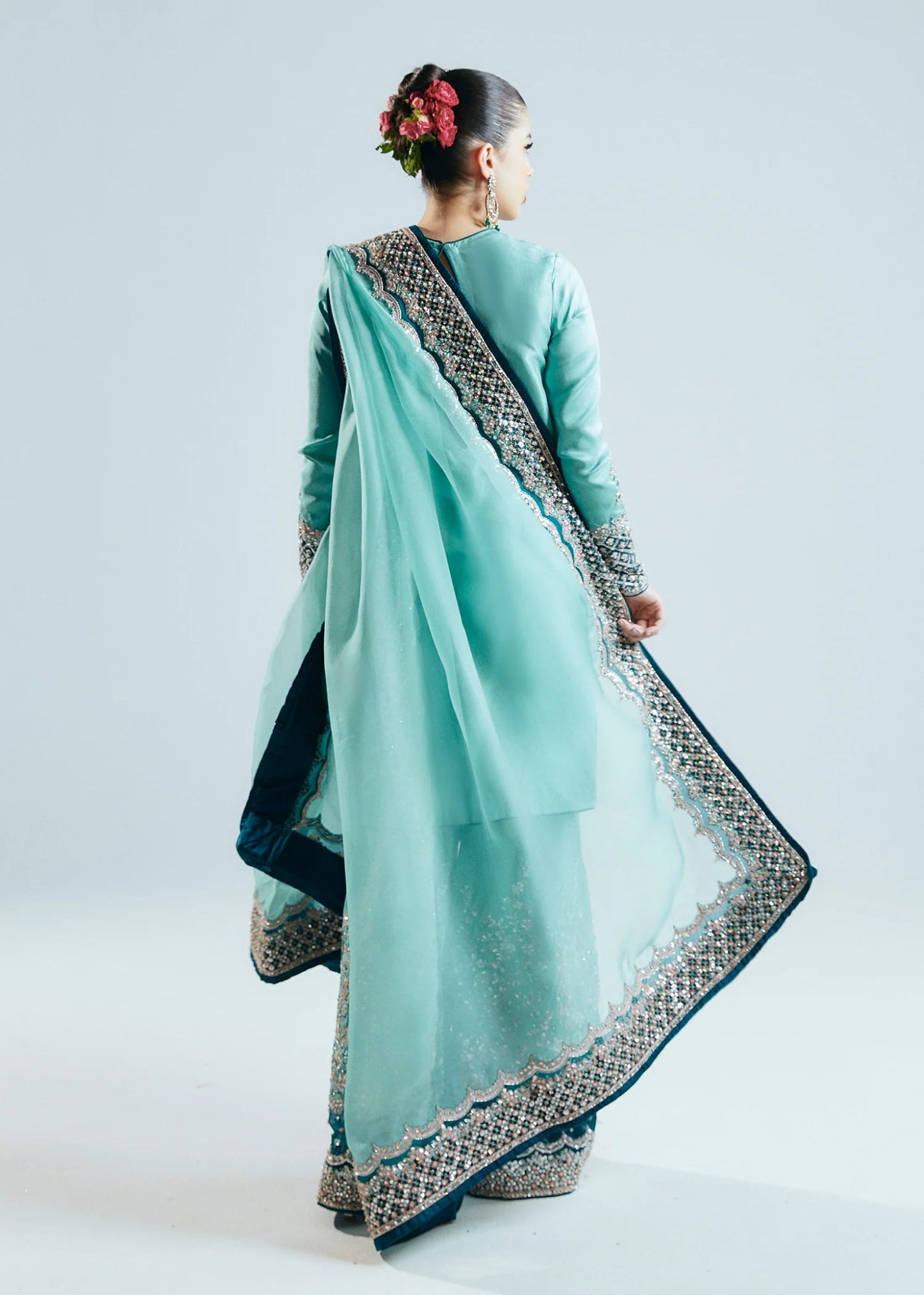 Model wearing a teal Hussain Rehar Reef dress with intricate embellishments from the Sitaray Formals collection. Perfect for weddings.