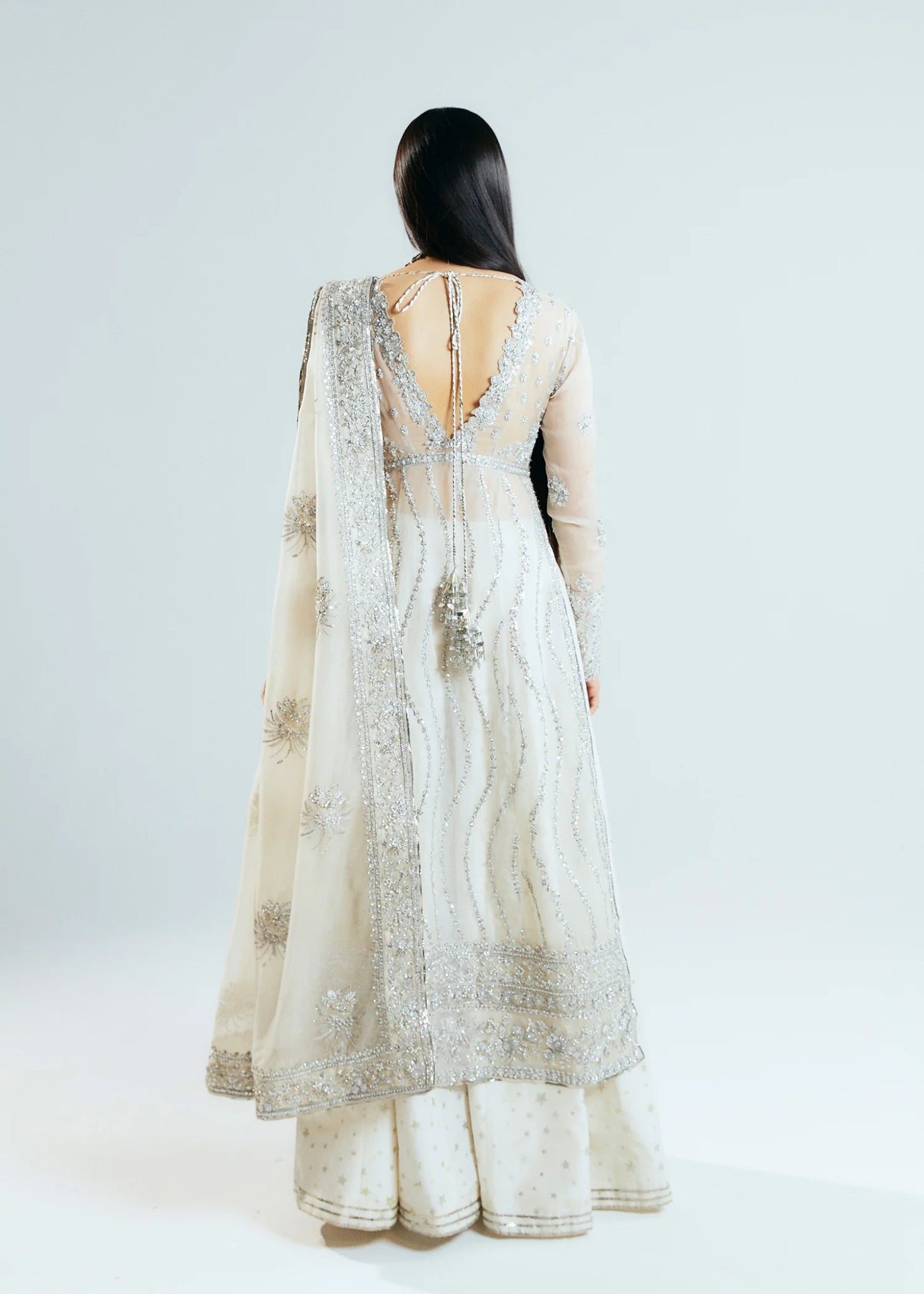 Model wearing a silver Hussain Rehar Seraph dress with intricate embellishments. Perfect for weddings, available in the UK online store.