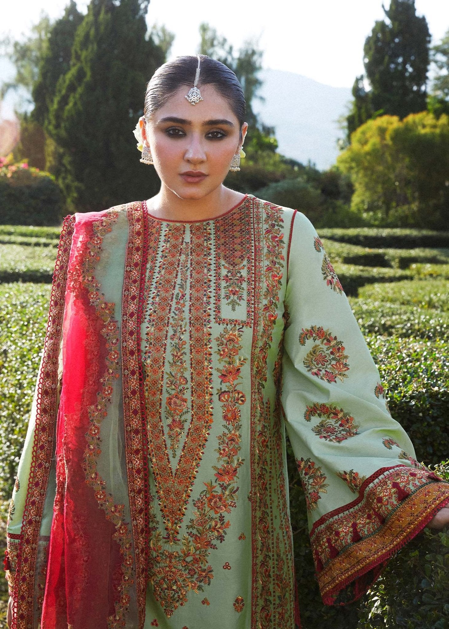 Model wearing light green Gul Bahar dress from Hussain Rehar's Zaiba Lawn '24 collection. Pakistani clothes online in UK. Beautiful floral embroidery.