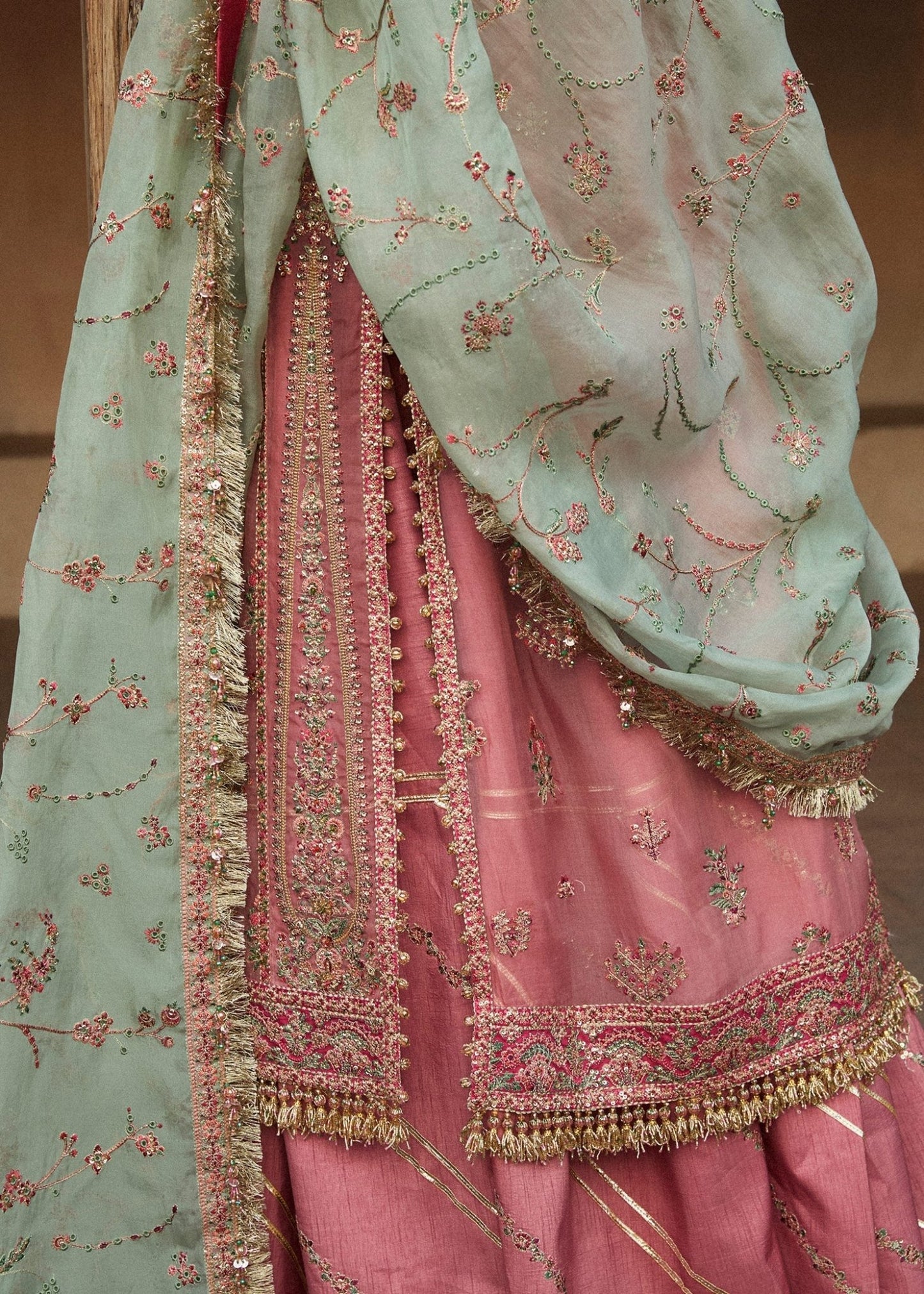 Model wearing a pink and mint green Aadoo dress from Hussain Rehar's Wedding Festive Sep '24 Collection, featuring intricate embroidery and embellishments. Pakistani wedding clothes available online in the UK.