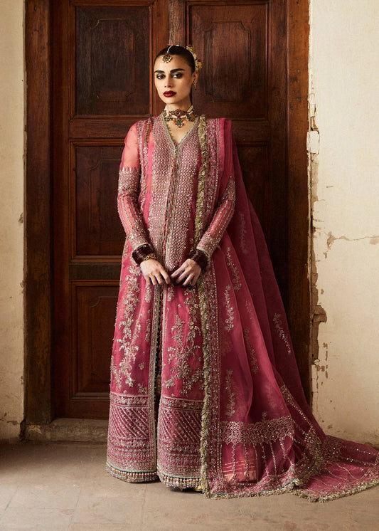 Model wearing a deep pink Marjani dress from Hussain Rehar's Wedding Festive Sep '24 Collection, featuring intricate gold embroidery. Pakistani wedding clothes available online in the UK.