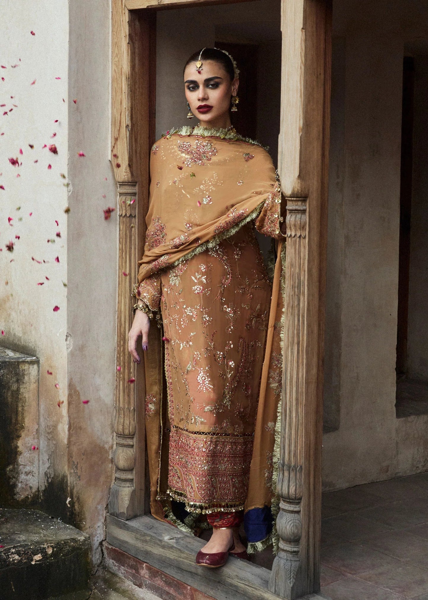 Model wearing a mustard - colored Talai dress from Hussain Rehar's Wedding Festive Sep '24 Collection, featuring intricate embroidery and embellishments. Pakistani wedding clothes available online in the UK.