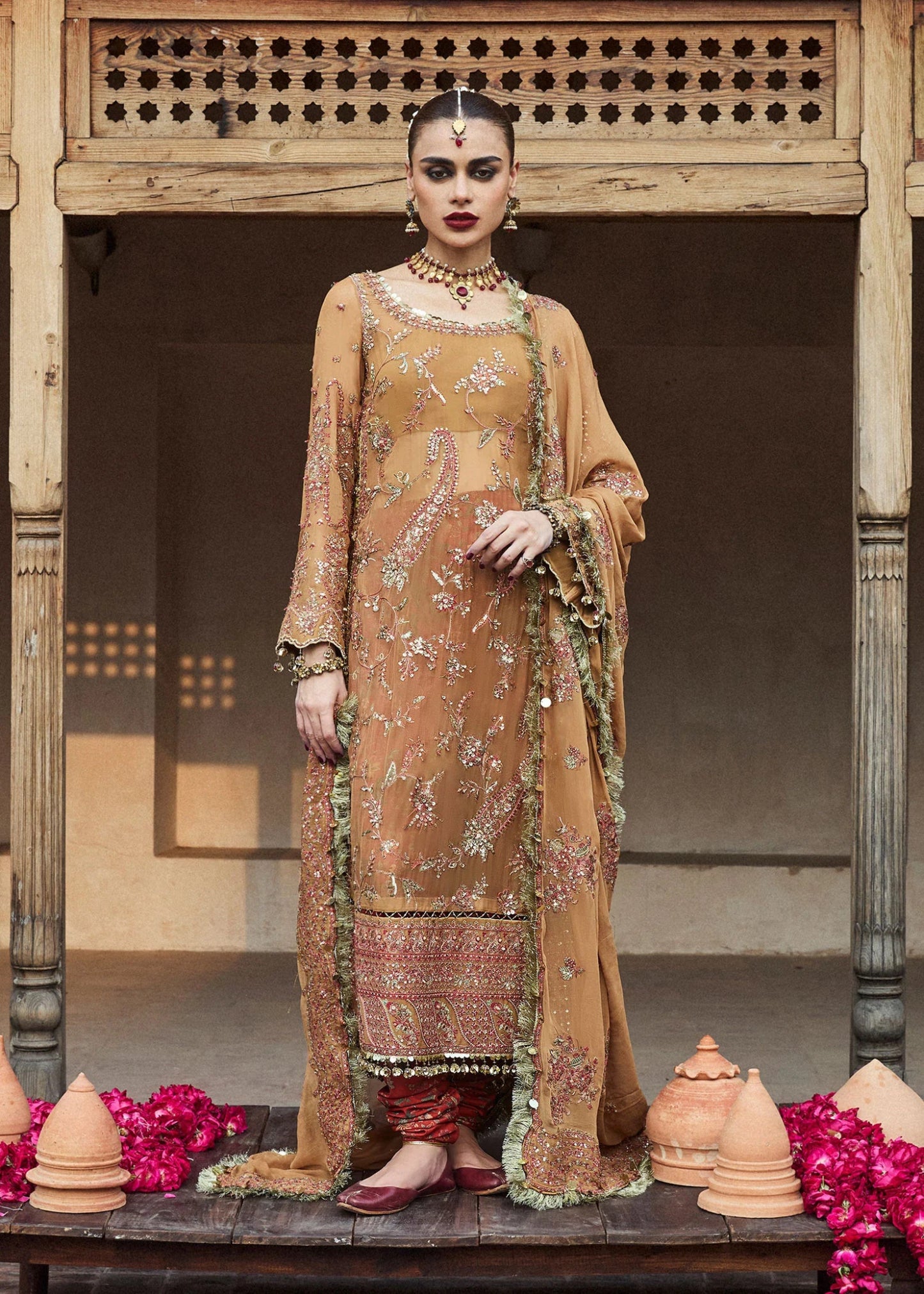 Model wearing a mustard - colored Talai dress from Hussain Rehar's Wedding Festive Sep '24 Collection, featuring intricate embroidery and embellishments. Pakistani wedding clothes available online in the UK.