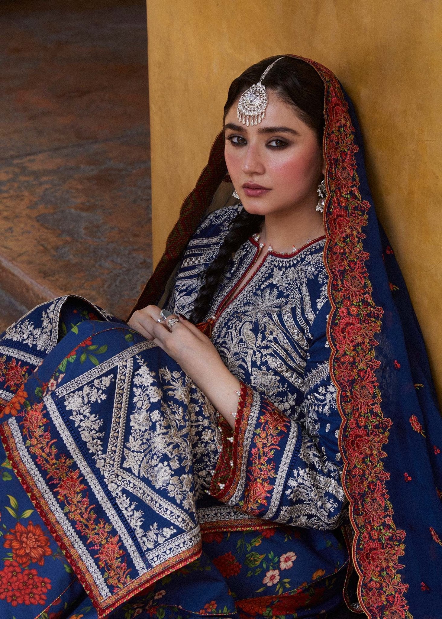 Model wearing blue Neelofar dress from Hussain Rehar's Zaiba Lawn '24 collection. Pakistani clothes online in UK. Detailed floral embroidery.