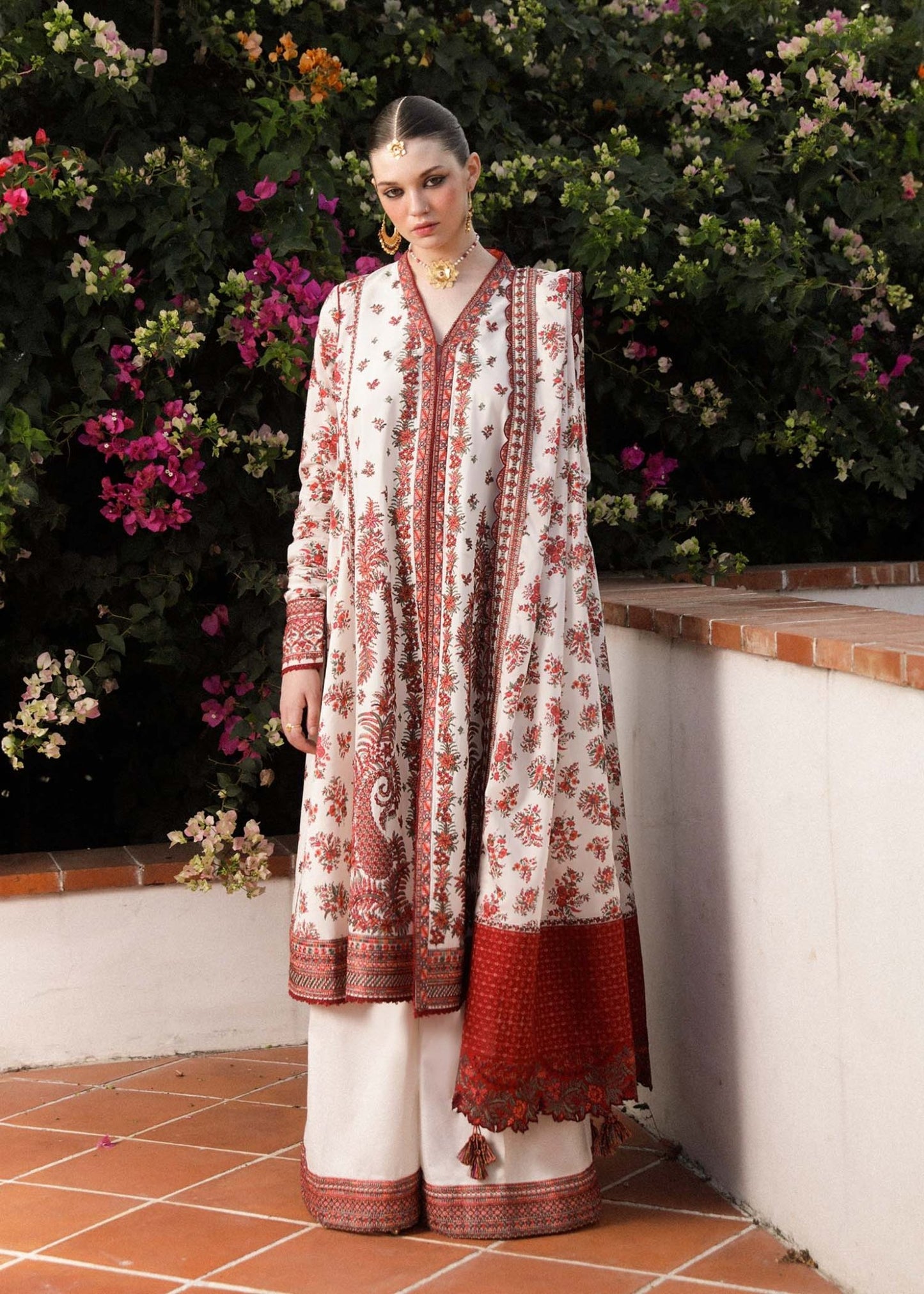 Model wearing Hussain Rehar Safaid dress with red floral patterns, chic Pakistani clothes UK.