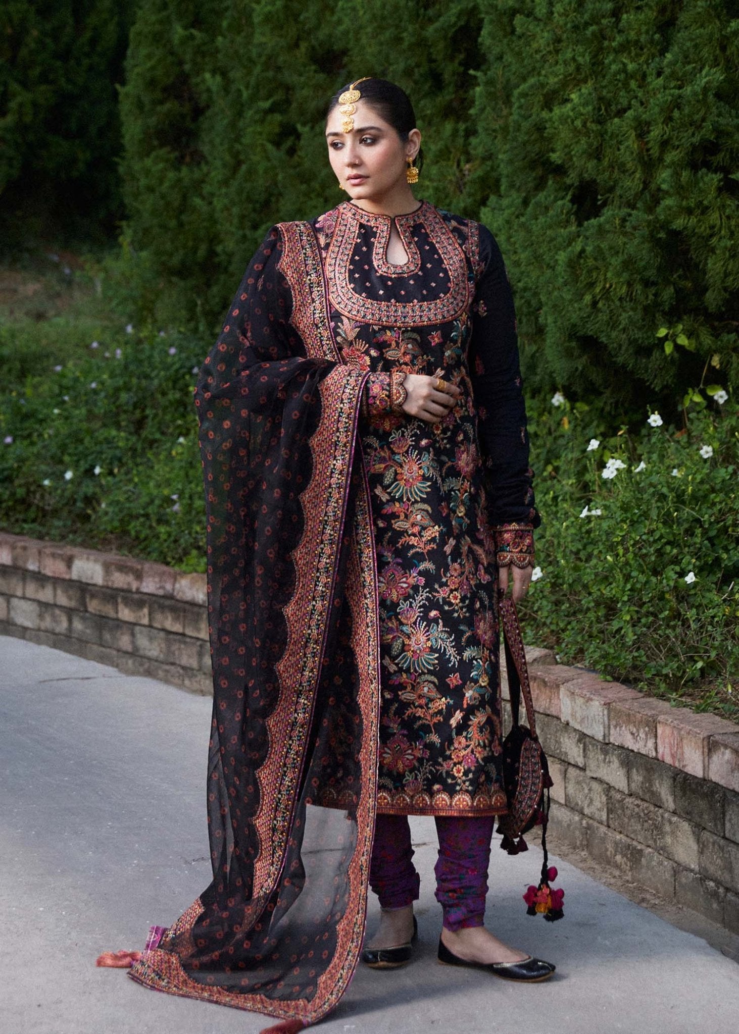 Model wearing Hussain Rehar Siyaan dress, black with floral print, traditional Pakistani clothes UK.