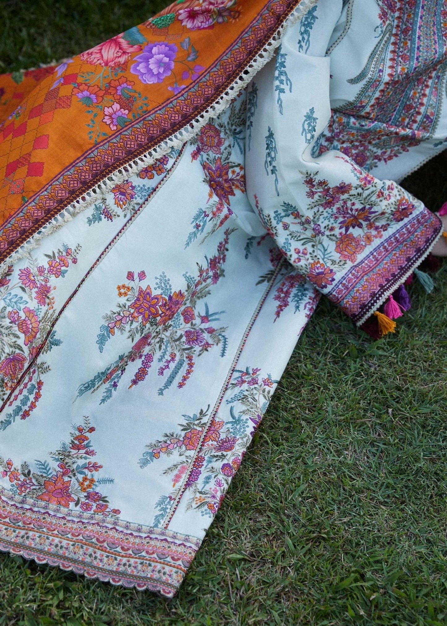 Model wearing a white Sumbul dress with colorful floral patterns from Hussain Rehar's Zaiba Lawn '24 collection. Pakistani clothes online in UK.