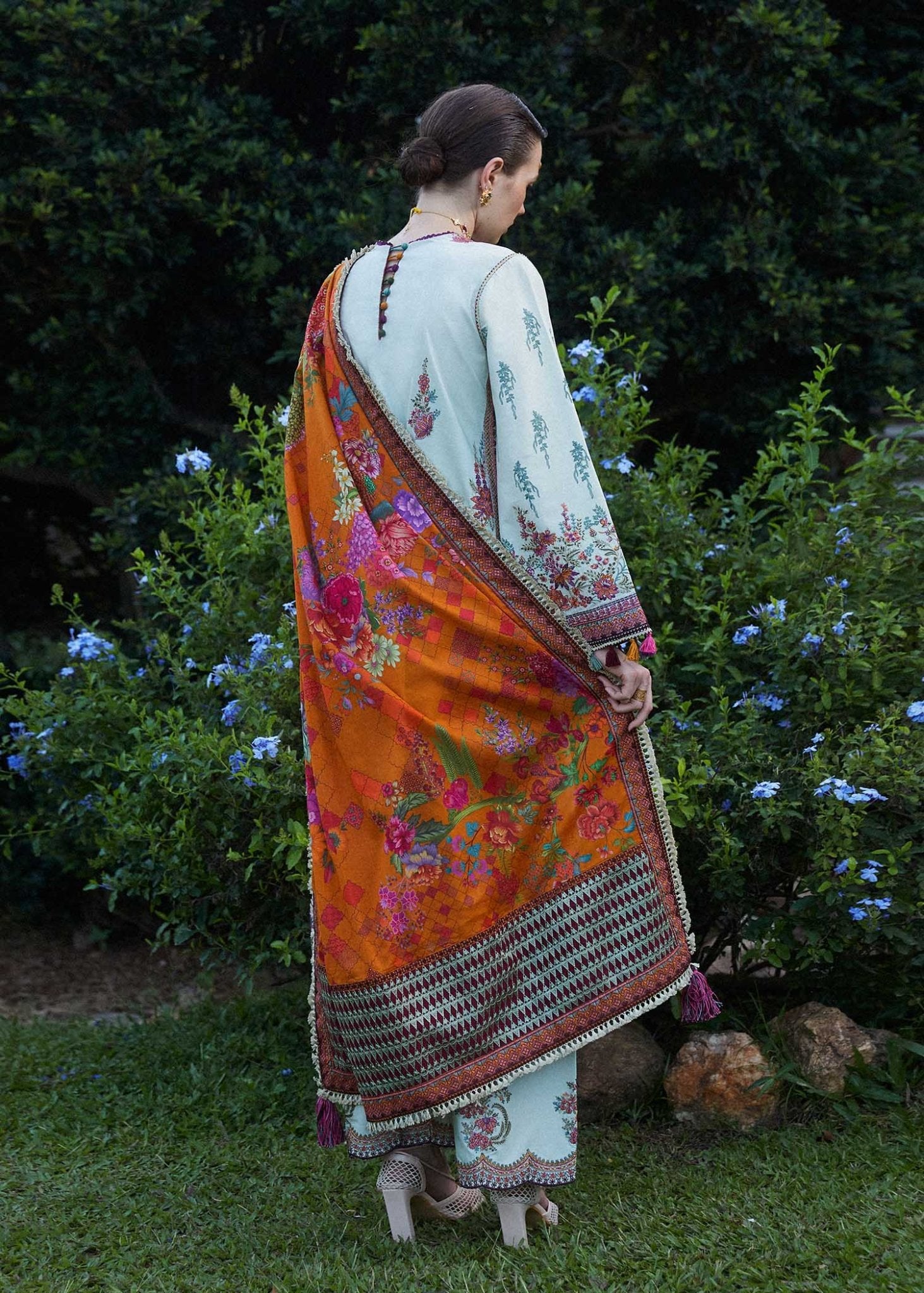 Model wearing a white Sumbul dress with colorful floral patterns from Hussain Rehar's Zaiba Lawn '24 collection. Pakistani clothes online in UK.