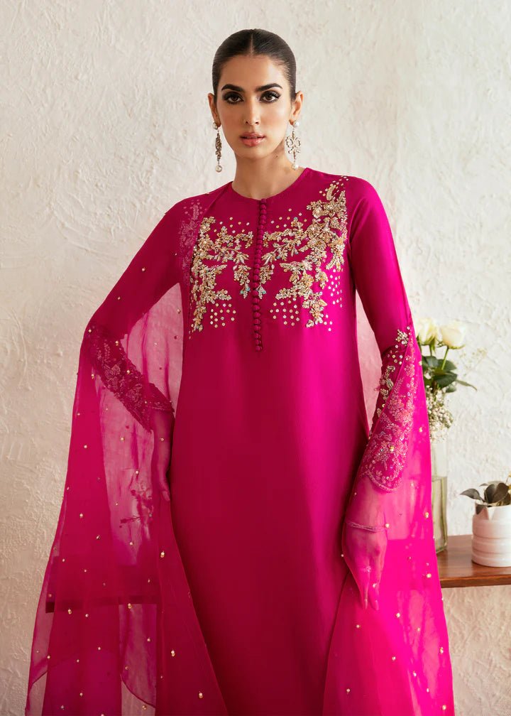 Model wearing a bright pink Myra dress from Kanwal Malik, featuring intricate golden embroidery on the bodice and sleeves. Pakistani clothes online in UK, wedding clothes.