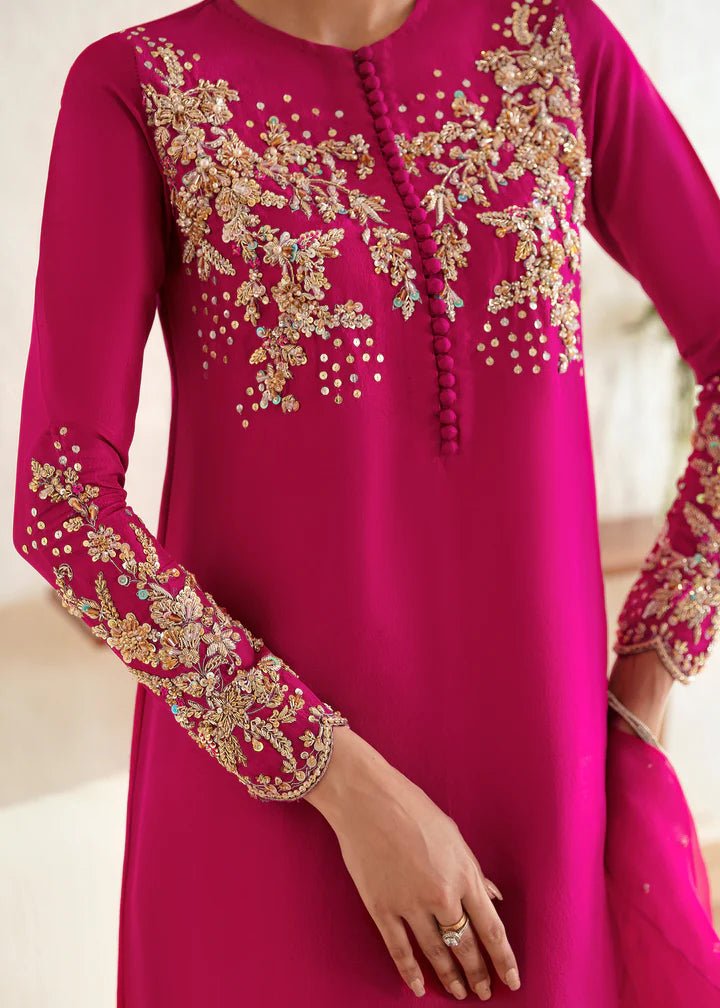 Model wearing a bright pink Myra dress from Kanwal Malik, featuring intricate golden embroidery on the bodice and sleeves. Pakistani clothes online in UK, wedding clothes.