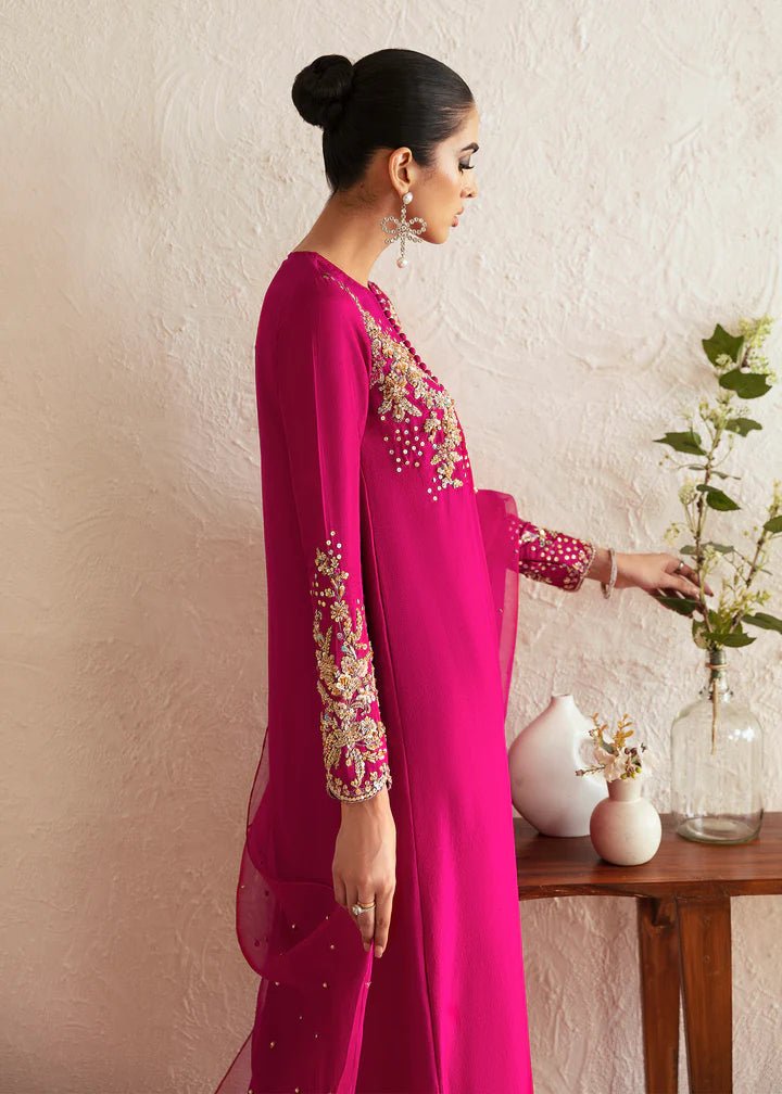 Model wearing a bright pink Myra dress from Kanwal Malik, featuring intricate golden embroidery on the bodice and sleeves. Pakistani clothes online in UK, wedding clothes.