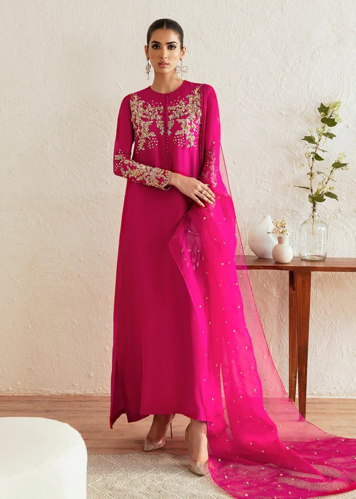 Model wearing a bright pink Myra dress from Kanwal Malik, featuring intricate golden embroidery on the bodice and sleeves. Pakistani clothes online in UK, wedding clothes.