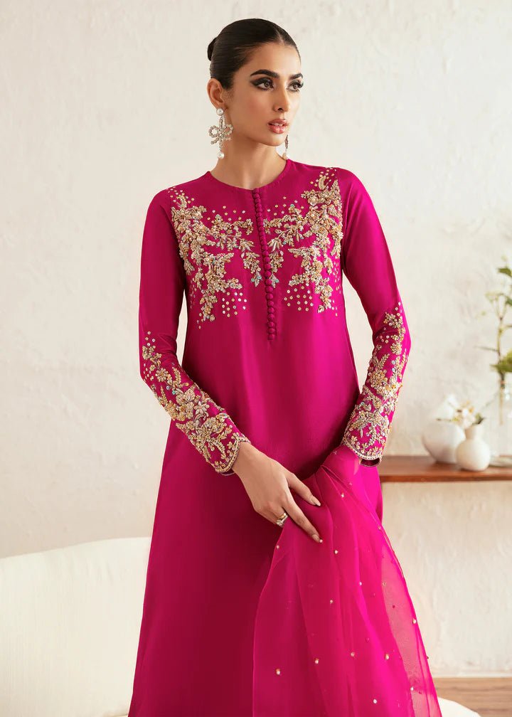 Model wearing a bright pink Myra dress from Kanwal Malik, featuring intricate golden embroidery on the bodice and sleeves. Pakistani clothes online in UK, wedding clothes.