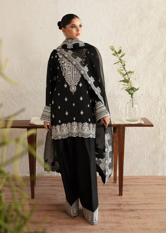 Model wearing a black Soha dress from Kanwal Malik's Amelie Luxury Pret collection. The outfit features intricate silver embroidery. Perfect for Pakistani clothes online in the UK, especially for wedding clothes and festive occasions.