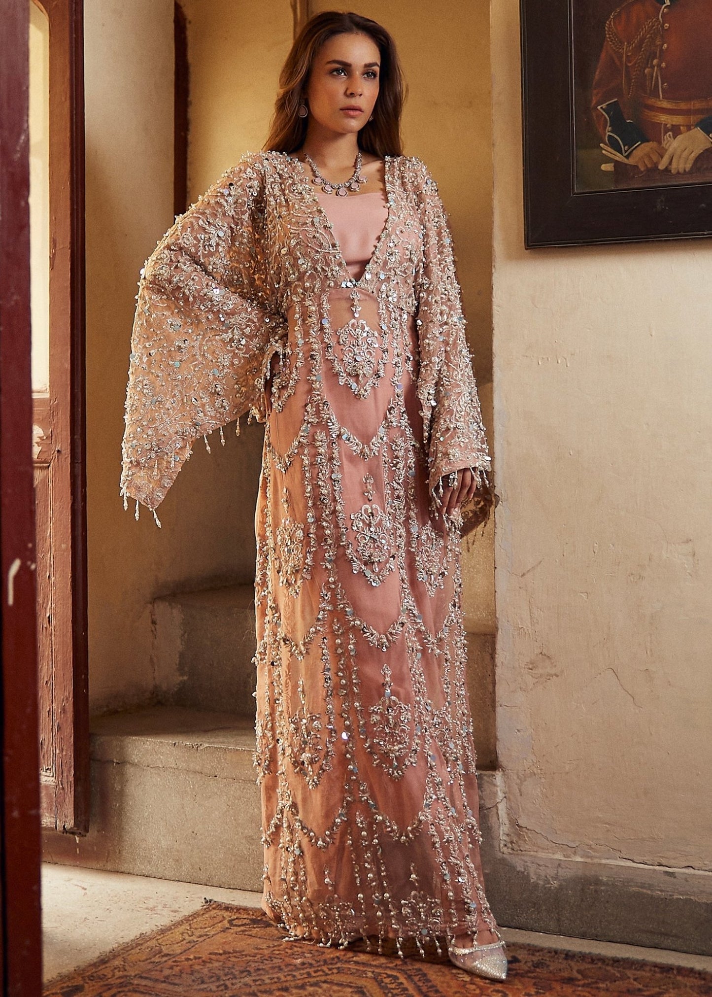 Model wearing a peach - colored Chamois wedding formal dress from Mushq, embellished with silver details. Pakistani wedding clothes online in the UK.