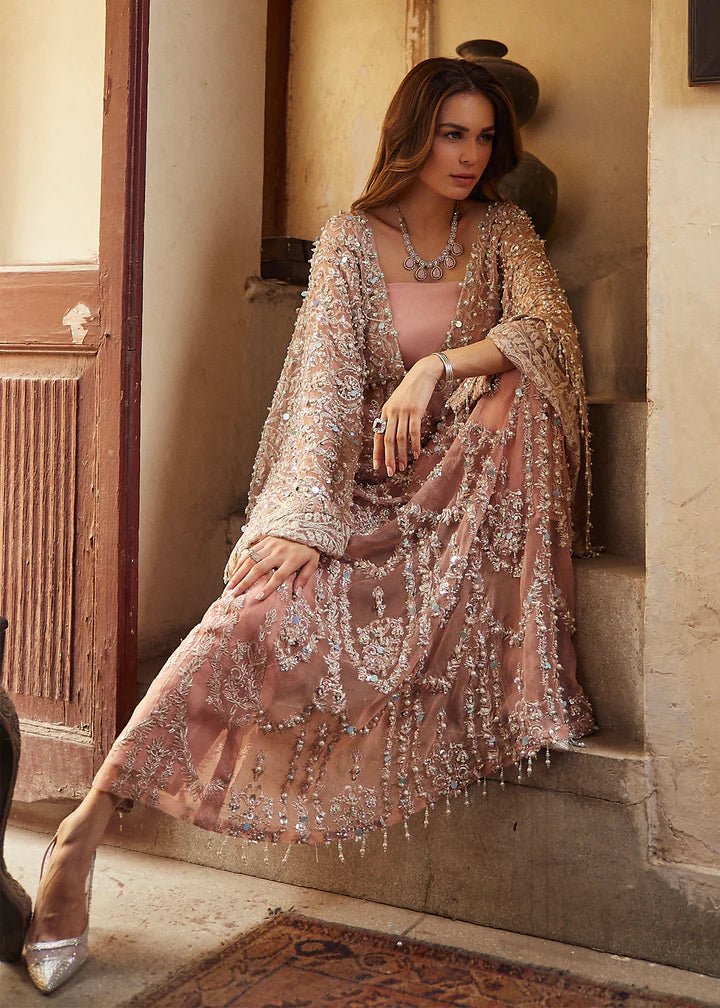 Model wearing a peach - colored Chamois wedding formal dress from Mushq, embellished with silver details. Pakistani wedding clothes online in the UK.