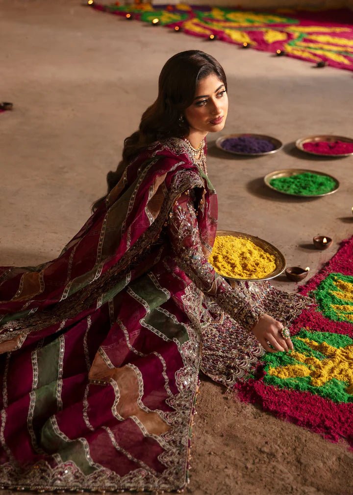 Model wearing Kanwal Malik Maahi Wedding Festive '24 ARMALA, a deep red ensemble with intricate gold embroidery, ideal for wedding celebrations. Available for Pakistani clothes online in the UK.